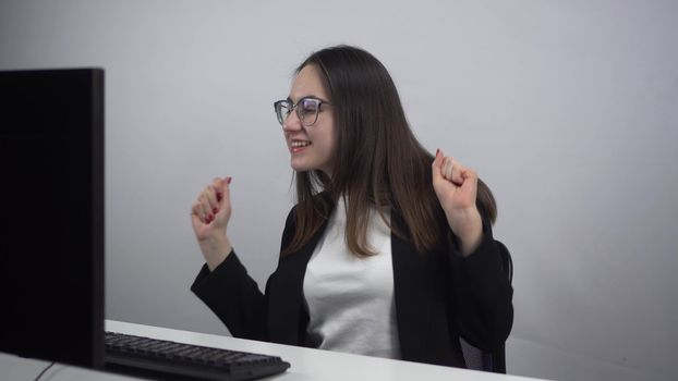 Businesswoman dances about the work done. A young woman dances cheerfully at the workplace in the office. 4k