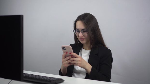 Businessman with a phone in his hands on a break in the office. Young woman chatting on a smartphone. Girl in a jacket and glasses. 4k