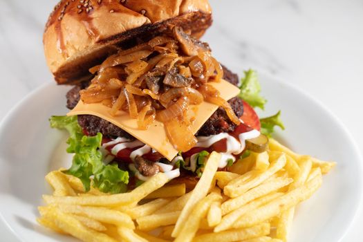 cheeseburger and fries on plate served at restaurant. High quality photo