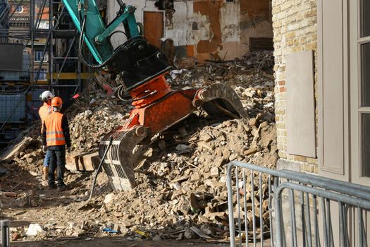 Ruined house. An excavator destroys a house with a bucket.