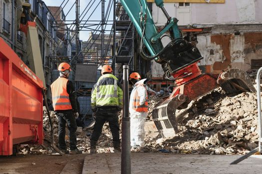 Ruined house. An excavator destroys a house with a bucket.