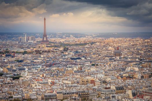 Paris skyline at golden sunset with Eiffel Tower above parisien roofs, Paris, France