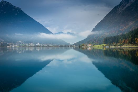 Sailboats on Achensee lake near Innsbruck at peaceful misty dawn, Tyrol alps, Austria