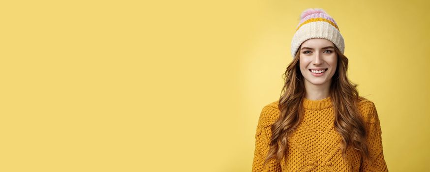 Attractive young friendly-looking outgoing girl dressed warm travel mountains skiing having fun spend winter holidays alps family, smiling broadly wearing corduroy hat sweater, yellow background.
