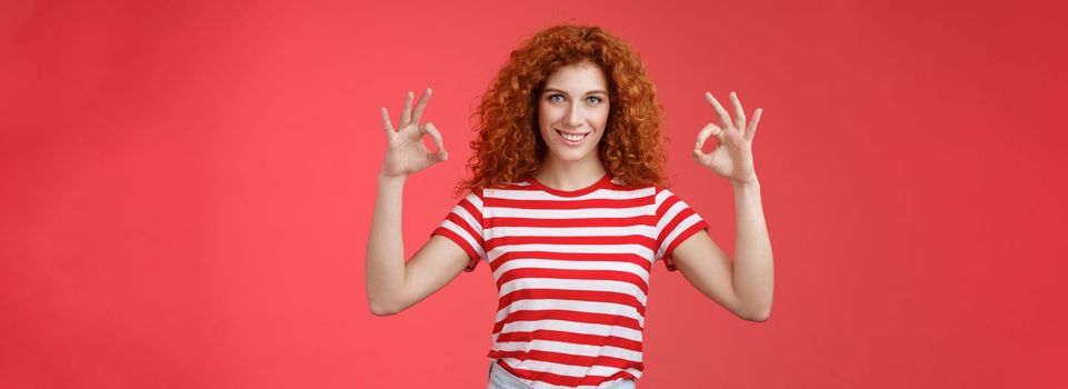 Motivated ambisious good-looking empowered young redhead curly girl assuring everything excellent show okay ok perfection gesture smiling assertive confidently approve like awesome choice.