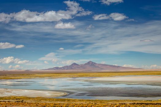 Salt lake reflection and idyllic volcanic landscape at Sunset, Atacama desert, Chile border with Bolivia