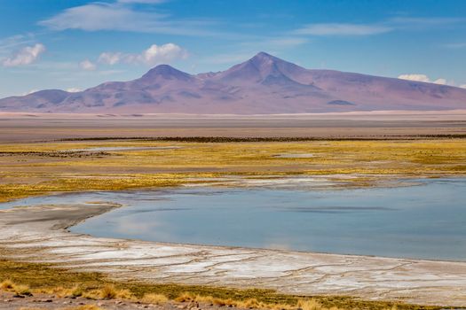 Salt lake reflection and idyllic volcanic landscape at Sunset, Atacama desert, Chile border with Bolivia