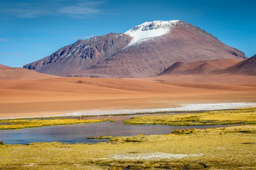 Salt lake reflection and idyllic volcanic landscape at Sunset, Atacama desert, Chile border with Bolivia