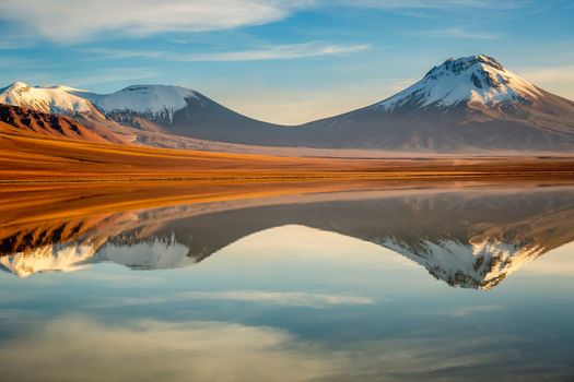 Salt lake Lejia reflection and idyllic volcanic landscape at Sunset, Atacama desert, Chile