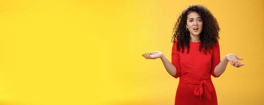 What your problem. Annoyed and confused pissed girlfriend with curly hair in elegant party dress shrugging with hands spread sideways and clueless grimace, waiting explanation during argument.