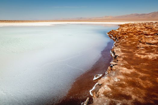 Salt lake reflection and idyllic volcanic landscape at sunrise, Atacama desert, Chile border with Bolivia