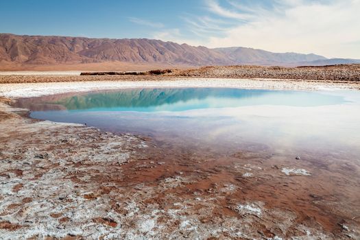 Salt lake reflection and idyllic volcanic landscape at sunrise, Atacama desert, Chile border with Bolivia