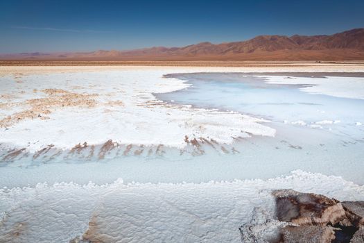 Salt lake reflection and idyllic volcanic landscape at sunrise, Atacama desert, Chile border with Bolivia