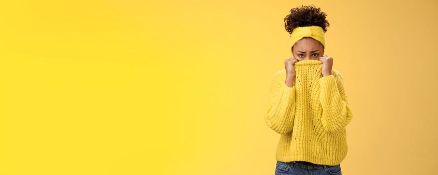 Cute upset scared timid insecure african-american offended girl hiding face pulling sweater collar nose frowning pouting look sorrow insulted afraid watching scary horror movie alone, need support.