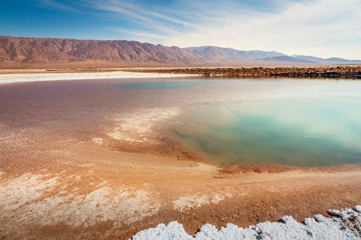 Salt lake reflection and idyllic volcanic landscape at sunrise, Atacama desert, Chile border with Bolivia