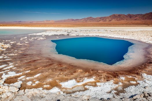Salt lake reflection and idyllic volcanic landscape at sunrise, Atacama desert, Chile border with Bolivia
