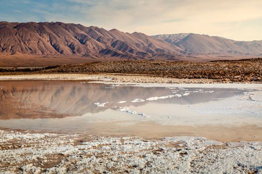 Salt lake reflection and idyllic volcanic landscape at sunrise, Atacama desert, Chile border with Bolivia