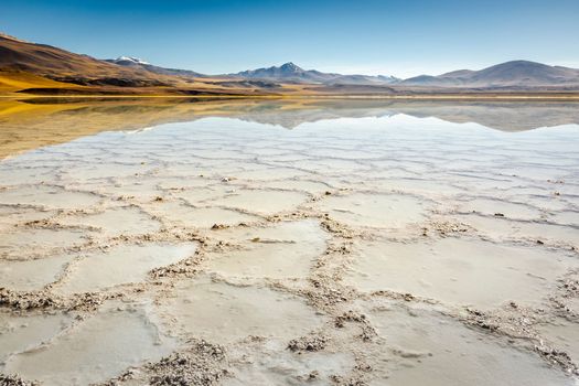 Salt lake reflection and idyllic volcanic landscape at sunrise, Atacama desert, Chile border with Bolivia