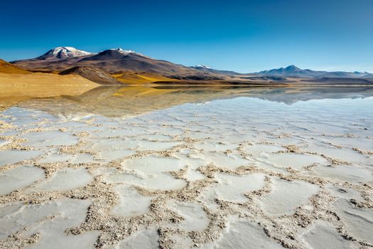 Salt lake reflection and idyllic volcanic landscape at sunrise, Atacama desert, Chile border with Bolivia