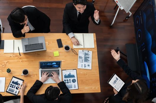 Top-view business team of financial data analysis meeting with business intelligence, report paper and dashboard on laptop for marketing strategy. Business people working together in office of harmony