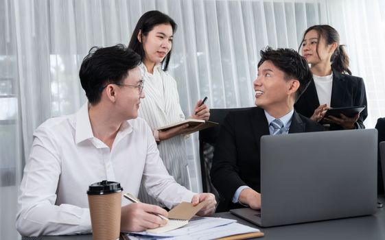 Harmony in office concept as business people analyzing dashboard paper together in workplace. Young colleagues give ideas at manager desk for discussion or strategy planning about project.