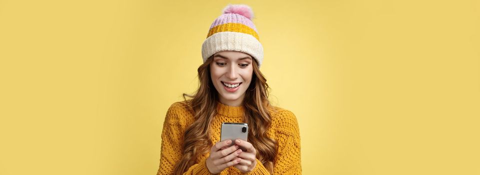 Amazed surprised cute girl receive good news reading exciting message hold smartphone widen eyes smiling mobile phone display, playing awesome cellphone game texting, send pics winters vacation.