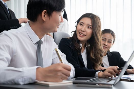 Harmony in office concept as business people analyzing dashboard paper together in workplace. Young colleagues give ideas at manager desk for discussion or strategy planning about project.