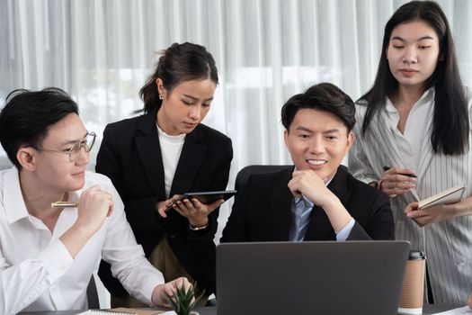 Harmony in office concept as business people analyzing dashboard paper together in workplace. Young colleagues give ideas at manager desk for discussion or strategy planning about project.