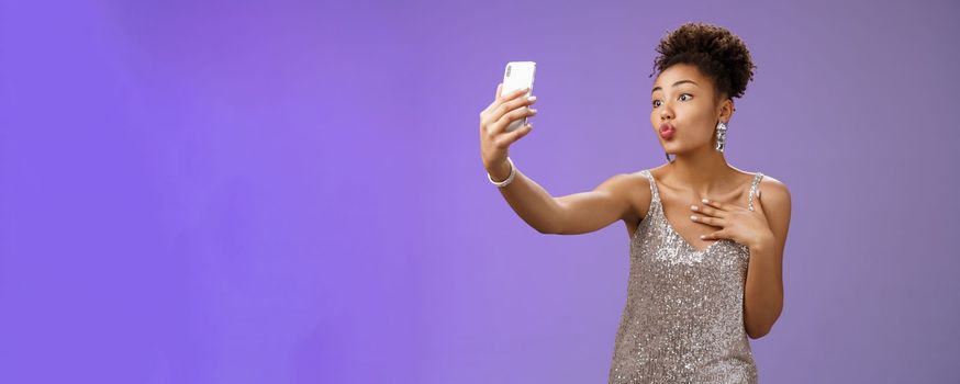Stylish silly feminine african-american woman. partying in silver stylish dress folding lips mwah gesture posing selfie taking photo during party night club looking flirty display camera.