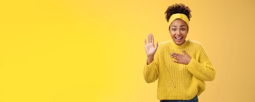 Fascinated amused young charming sincere african-american girl headband sweater press hand chest raise palm swearing promising do her best standing excited grinning happily, posing yellow background.