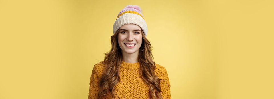 Attractive young friendly-looking outgoing girl dressed warm travel mountains skiing having fun spend winter holidays alps family, smiling broadly wearing corduroy hat sweater, yellow background.