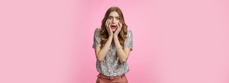 Shocked concerned attractive female student gasping gosh what happened widen eyes shocked drop jaw panicking freak-out touching face worried, standing anxious pink background. Copy space