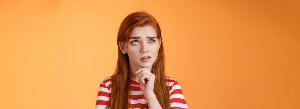 Perplexed redhead woman trying make calculations mind, frowning focused, look up puzzled thoughtful, touch chin, thinking, pondering important decision, make choice, solve problem.