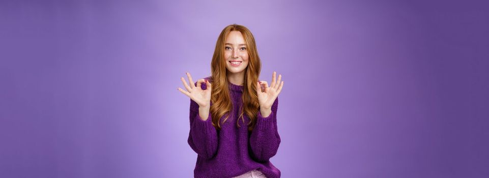 Girl loves her new haircut showing okay gesture with both hands and smiling delighted, feeling happy and satisfied, posing in purple outfit over violet background pleased with perfect customer service.