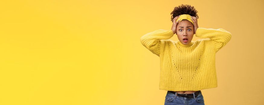 Troubled concerned perplexed female african-american employee duty look complicated panic hold hands head widen eyes shocked face troubles nervously thinking look anxious camera, yellow background.