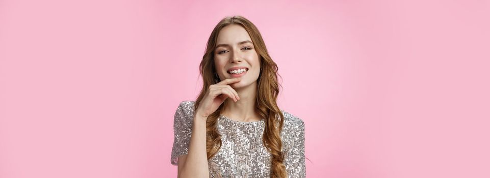 Flirty sensual attractive caucasian party girl wearing fashioable shiny blouse raise head arrogant smiling delighted coquettish, seducing you grinning satisfied confident, standing pink background.