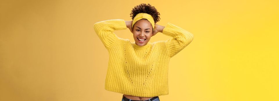 Attractive lucky optimistic african-american woman having fun lay back hands behind head smiling laughing happily enjoying perfect day-off work relaxing spend leisure fun, yellow background.