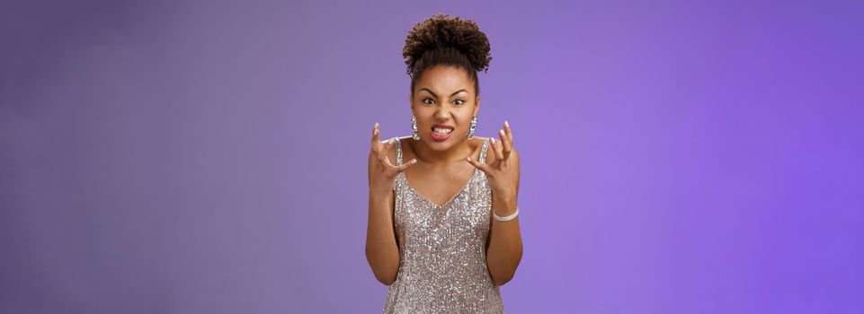 Annoyed pissed arrogant freak-out african american woman. in silver dress squeeze fists angry frowning grimacing anger furiously look camera bothered yell rage react outrageous disrespect.
