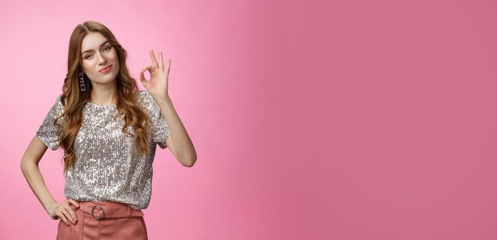 Not bad, you good. Portrait impressed glamour cheeky girlfriend smirking satisfied show okay ok gesture tilting head checking out your outfit pleased, standing confident pink background.