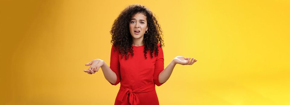 What your problem. Annoyed and confused pissed girlfriend with curly hair in elegant party dress shrugging with hands spread sideways and clueless grimace, waiting explanation during argument.