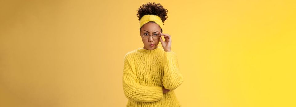 Suspicious strict serious-looking attractive clever african-american female student check glasses smirking disapproval frowning displeased bad classmate behaviour standing doubtful look disbelief.