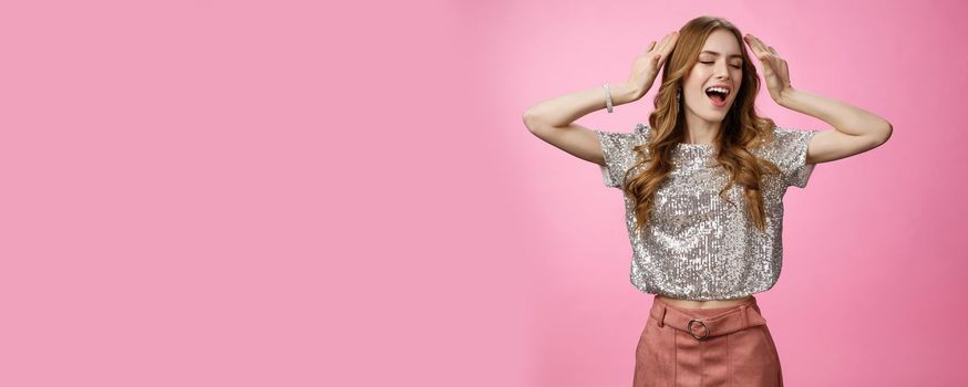 Attractive carefree sassy confident stylish woman wearing glittering blouse raise hands singing along music having fun dancing party dance-floor enjoying awesome evening night-out, pink background.