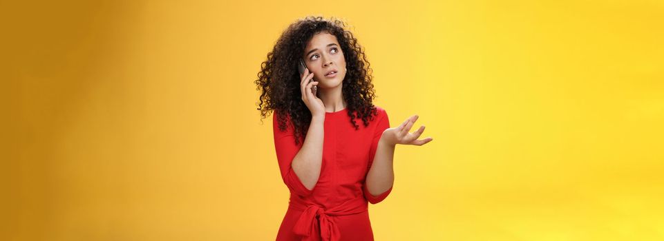 Lifestyle. Concerned and sad female friend telling details of bad situation happened on mobile phone discussing upset things with unhappy face gesturing with raised hand holding smartphone pressed to ear.