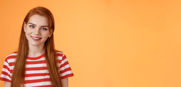 Close-up tender cute redhead young woman smiling joyfully, express happiness friendly emotions, look camera silly lovely grin, gaze satisfied, chat delighted, pleasant conversation orange background.