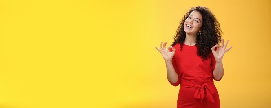 Lifestyle. Charming girl living dream standing happy and satisfied as liking new apartment rent with boyfriend showing okay gesture and tilting head with broad smile approving cool place over yellow background.