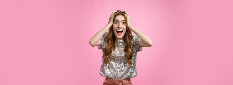 Excited happy surprised charming glamour young girl winning unexpectedly grab head amazed drop jaw smiling look camera astonished thrilled happiness, standing astonished pink background.