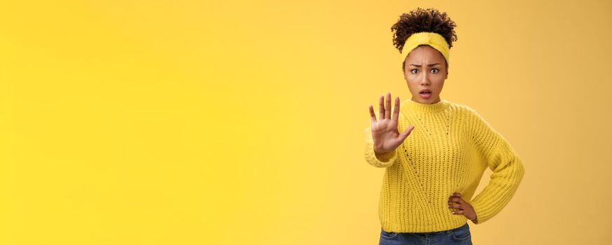 Afraid shocked insecure woman trying show voice be brave extend arm enough stop refusal gesture look frightened insecure unconfident rejecting declining offensive proposal, yellow background.