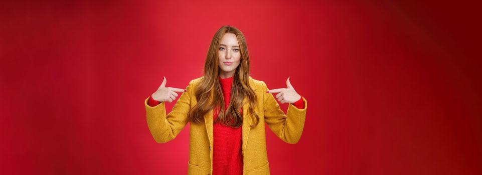 Lifestyle. Self-assured assertive and optimsitic charming female entrepreneur with ginger hair in yellow coat pointing at herself proudly brag own success or willing to be candidate smiling confident.