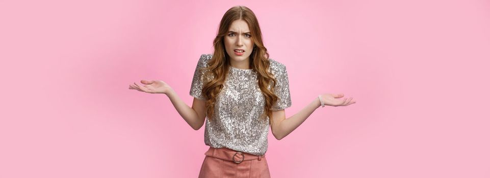 Pissed off annoyed glamour arrogant european woman arguing shrugging cringing displeased bothered spread hands sideways dismay, fighting confused questioned irritated, standing pink background.