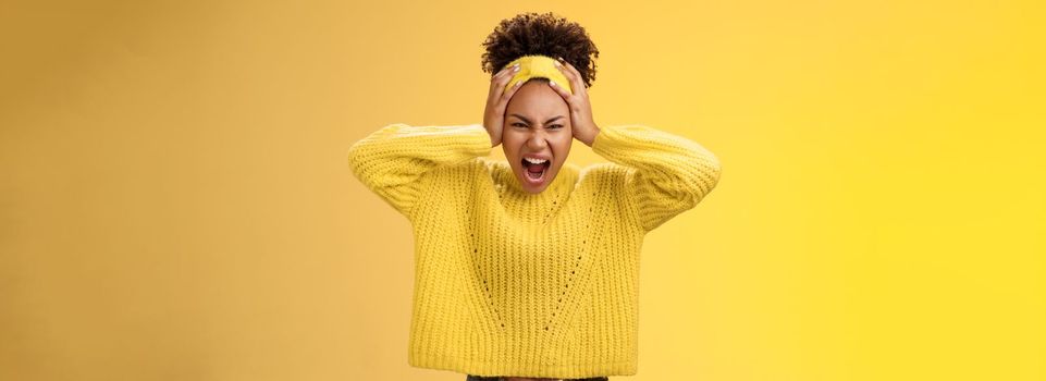 Furious outraged pissed insane african-american girl go crazy freak-out yell shouting agressive look annoyed fed up touching head grimacing scary dangerous very stressed, yellow background.